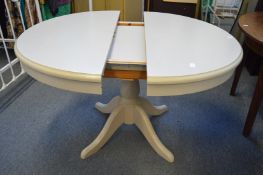 A grey painted circular extending pedestal dining table.