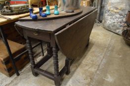 An old oak drop-leaf gate-leg dining table.