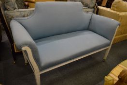 A small settee or window seat with white painted frame and pale blue upholstery.