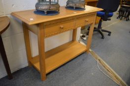 A modern light oak two drawer side table.