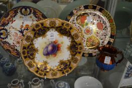 A Royal Worcester fruit decorated plate (faults) and two Crown Derby Imari decorated plates together