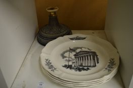 A set of four collectors plates and a metal stand.