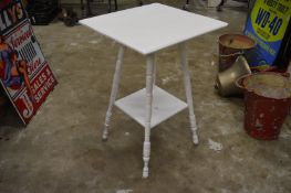 A white painted two-tier occasional table.