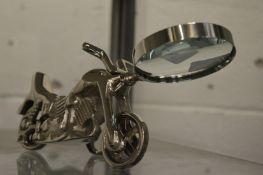 A novelty magnifying glass, the handle modelled as a motorbike.
