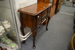 A reproduction walnut narrow lowboy.