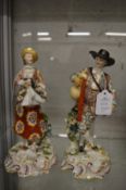 A pair of porcelain figures, possibly Chelsea, depicting male and female with dog and sheep at their
