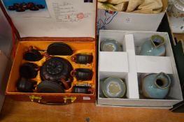 A Japanese Yixing tea set, boxed and a saki set, boxed.