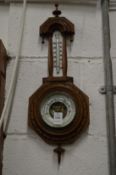 A small carved oak barometer/thermometer.