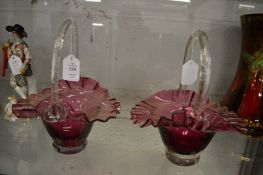 A pair of ruby tinted glass baskets.