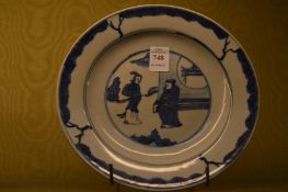 A Chinese blue and white plate decorated with figures.