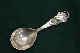 A silver caddy spoon.