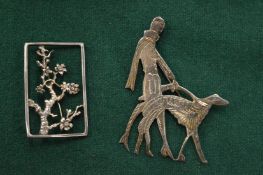 A decorative silver brooch designed by P Bolton together with another silver brooch of a lady