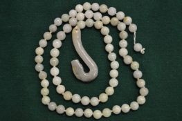 A jade bead necklace with carved jade pendant.