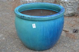 A large turquoise glazed planter.