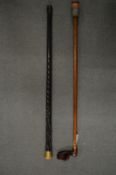 A gilt metal mounted carved wood walking stick and a modern walking stick.
