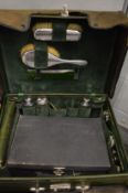 A green leather cased travelling toiletry set containing numerous silver backed and silver topped