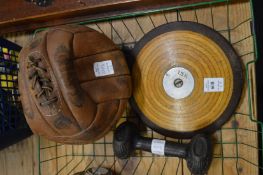 An old discus, leather football and a dumb bell.
