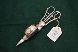 A plated candle snuffer/wick trimmer.