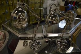 A pair of chrome plated angle poise table lamps.