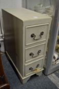 A pale green painted three drawer pedestal chest.