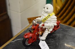 A cast iron Michelin man on a motor bike.