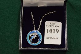 A sterling silver and enamel dolphin pendant and chain.