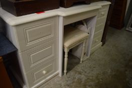 A white wood kneehole dressing table with mirror and stool.