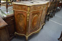 A French style ormolu mounted and marquetry inlaid serpentine fronted commode (lacking marble top).