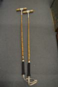 Two polo mallets.