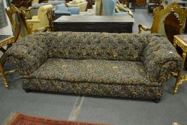 A Victorian Chesterfield settee upholstered in a tapestry style fabric.