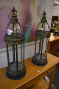 A pair of large metal and glass lanterns.