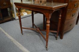A Victorian rectangular fold-over swivel top card table on turned supports.