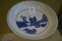 A Chinese circular blue and white dish decorated with a mythological beast.