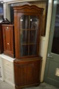 A yew wood standing corner cabinet.