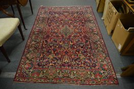 A Persian rug, red ground with floral decoration, 226cm x 142cm.