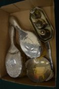 A silver dish, silver backed brushes, plated condiments.