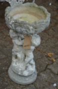 A pair of reconstituted stone figural bird baths.