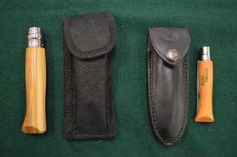 Two Opinel folding knives with pouches.