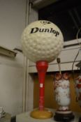 A large Dunlop advertising sign modelled as a golf ball on a golf tee.