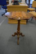 A Victorian walnut tripod drop-flap games table with drawers to each end and inlaid chess board
