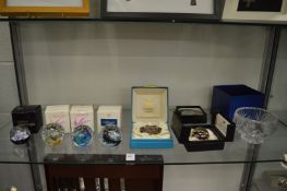 Various glass paperweights with original boxes and a glass bowl.