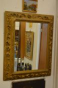 A large ornate gilt framed wall mirror.