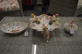 A Dresden floral decorated porcelain supported by cherubs and two other items.
