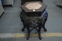 A Chinese carved hardwood urn stand with marble inset top.