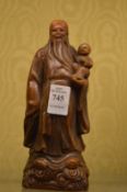 A Chinese faux horn model of a seated figure holding a child.
