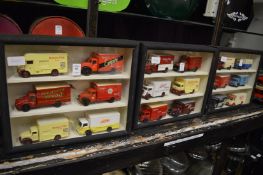 Three small glazed cases containing model advertising lorries.
