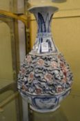 A large Chinese bottle vase with moulded decoration to the body.