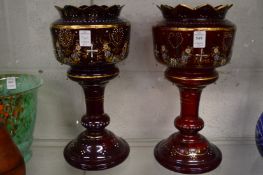 A pair of Victorian ruby glass and gilt decorated lustre bodies.