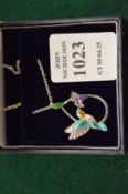 A sterling silver and enamel humming bird pendant and chain.