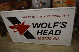 A large painted pressed metal sign for Wolf's Head Motor Oil, together with a cut-out cardboard
